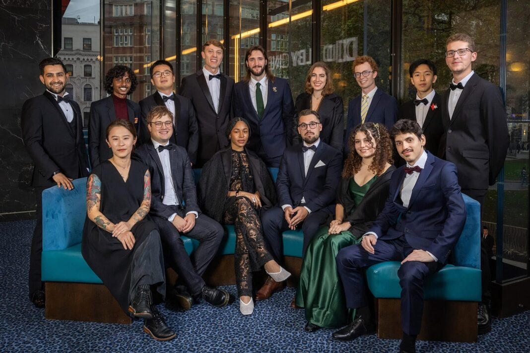 A group photo of the 15 student winners of the 51st Student Academy Awards, dressed in formal attire, posing at the ODEON Luxe Leicester Square in London.
